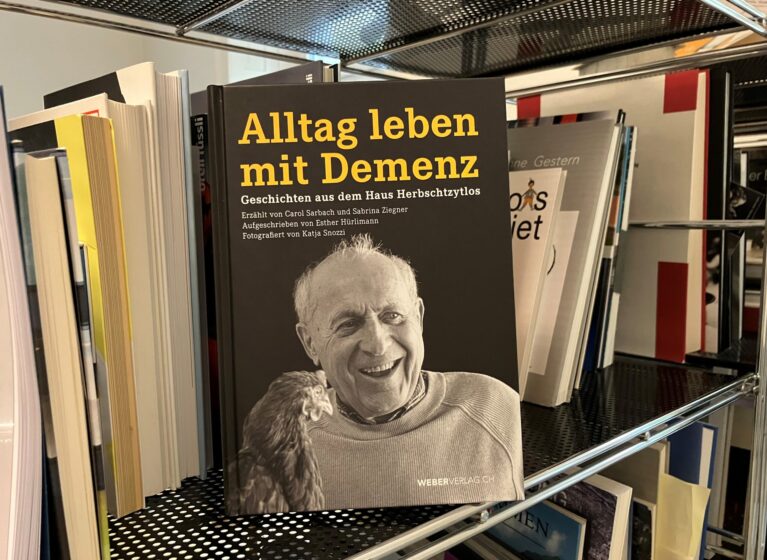Buch über Demenz steht in einem alltäglichen Büchergestell.